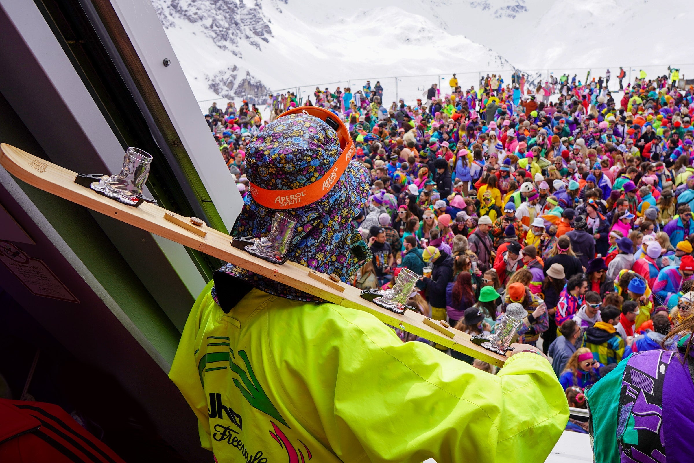 Apres-Ski: Wintersportler stoßen mit Jagertee vor einer Berghütte an