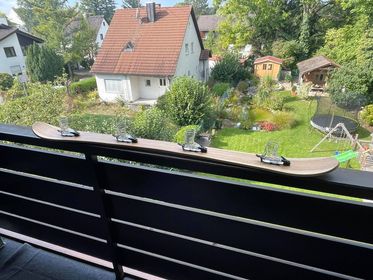 Kleine Runde spielt leise Karten-Trinkspiele auf einem Balkon am Abend