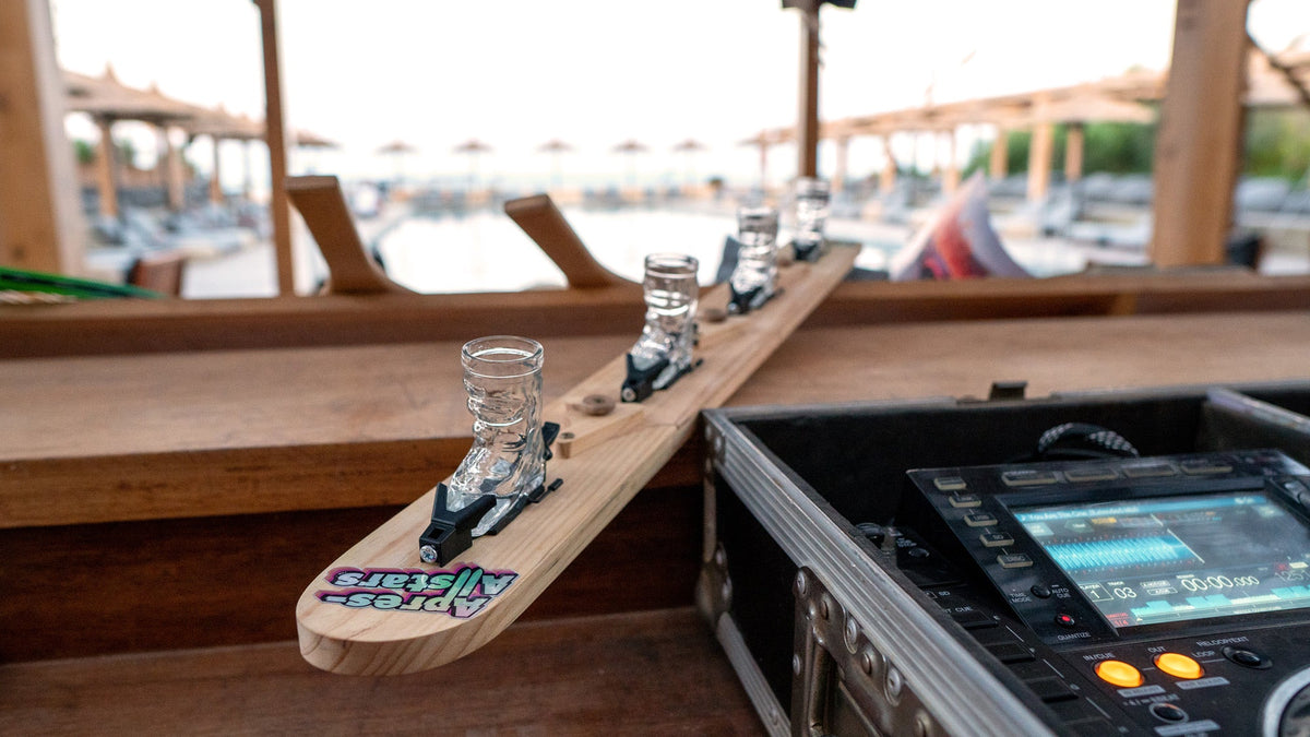Shotski mit vier Skischuh-Gläsern am DJ-Pult einer Open-Air-Party