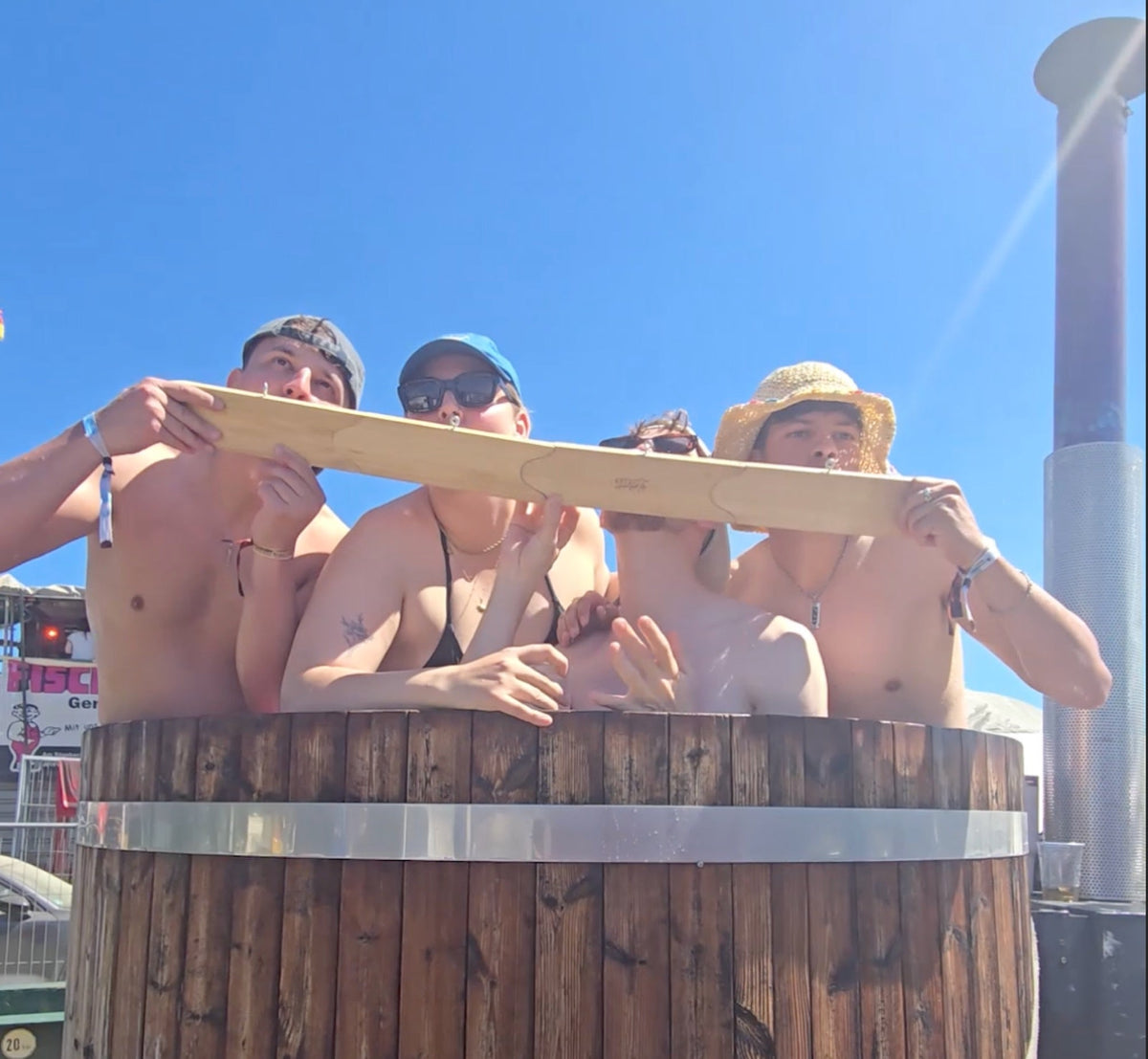 Freunde nutzen den Shotski als Festival-Gadget im Holz-Whirlpool