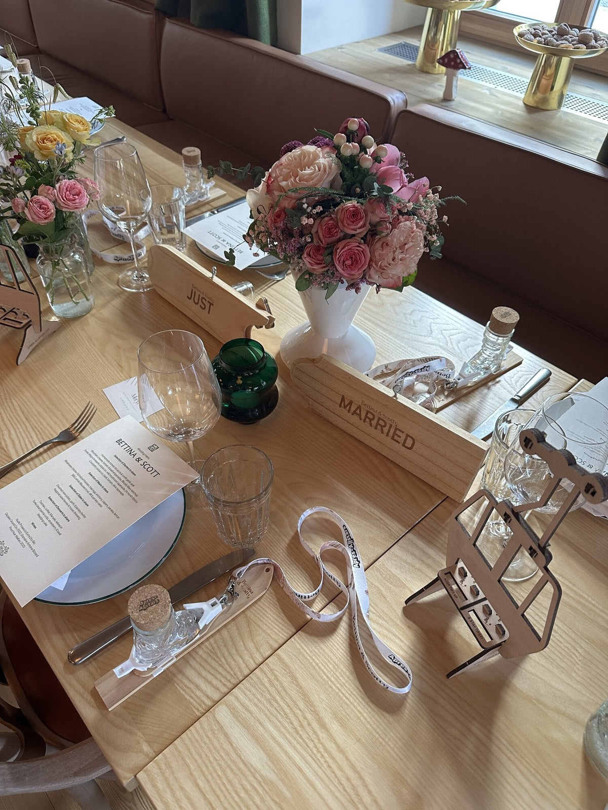 Hochzeitstafel mit Just-Married-Schildern und der Holz-Gondel mit Schnapsglaesern — Hochzeitsspiele fuer Gaeste