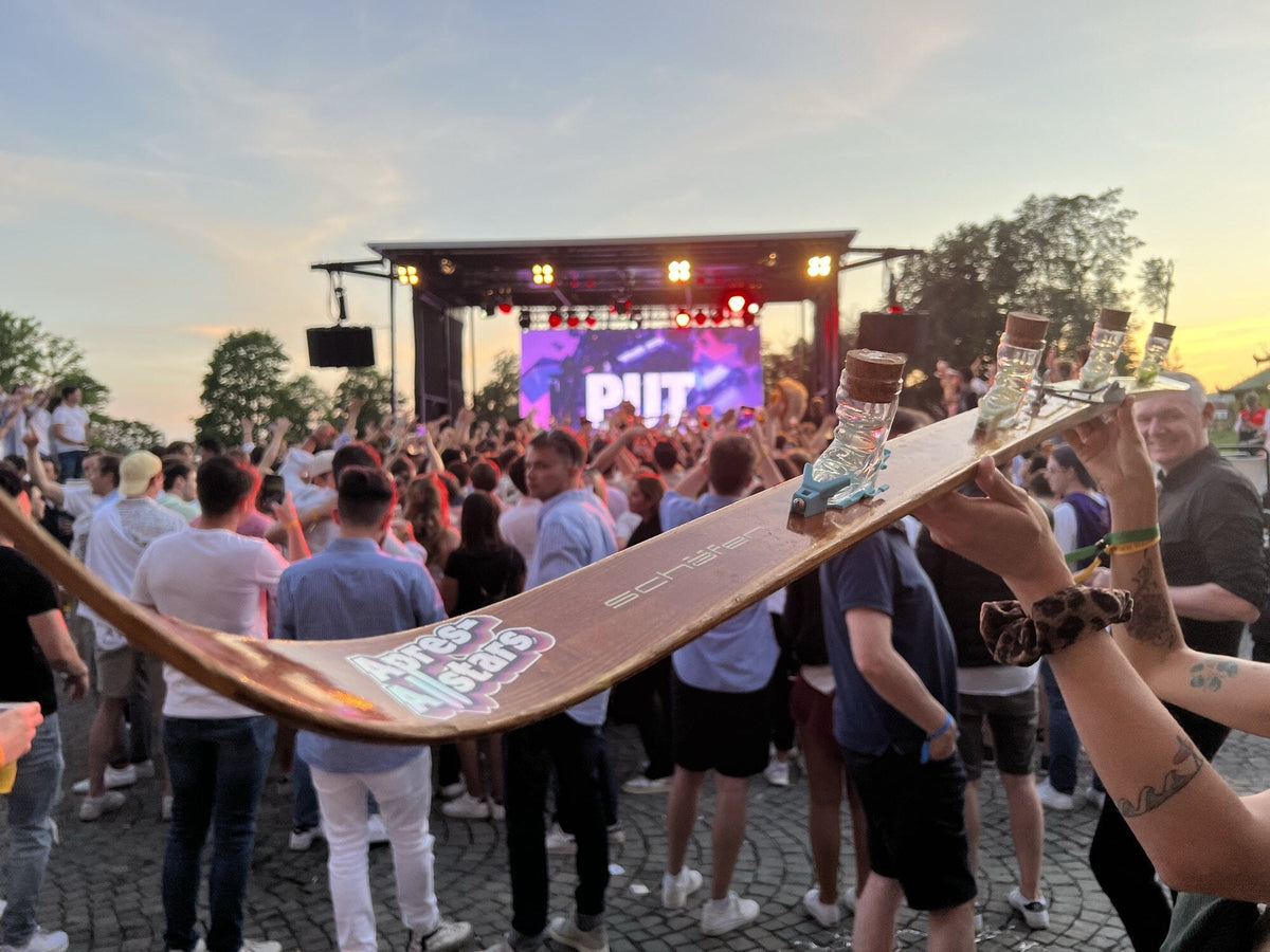 Shotski wird in der Festivalmenge vor der Buehne hochgehalten — Outdoor-Trinkspiele auf dem Festival