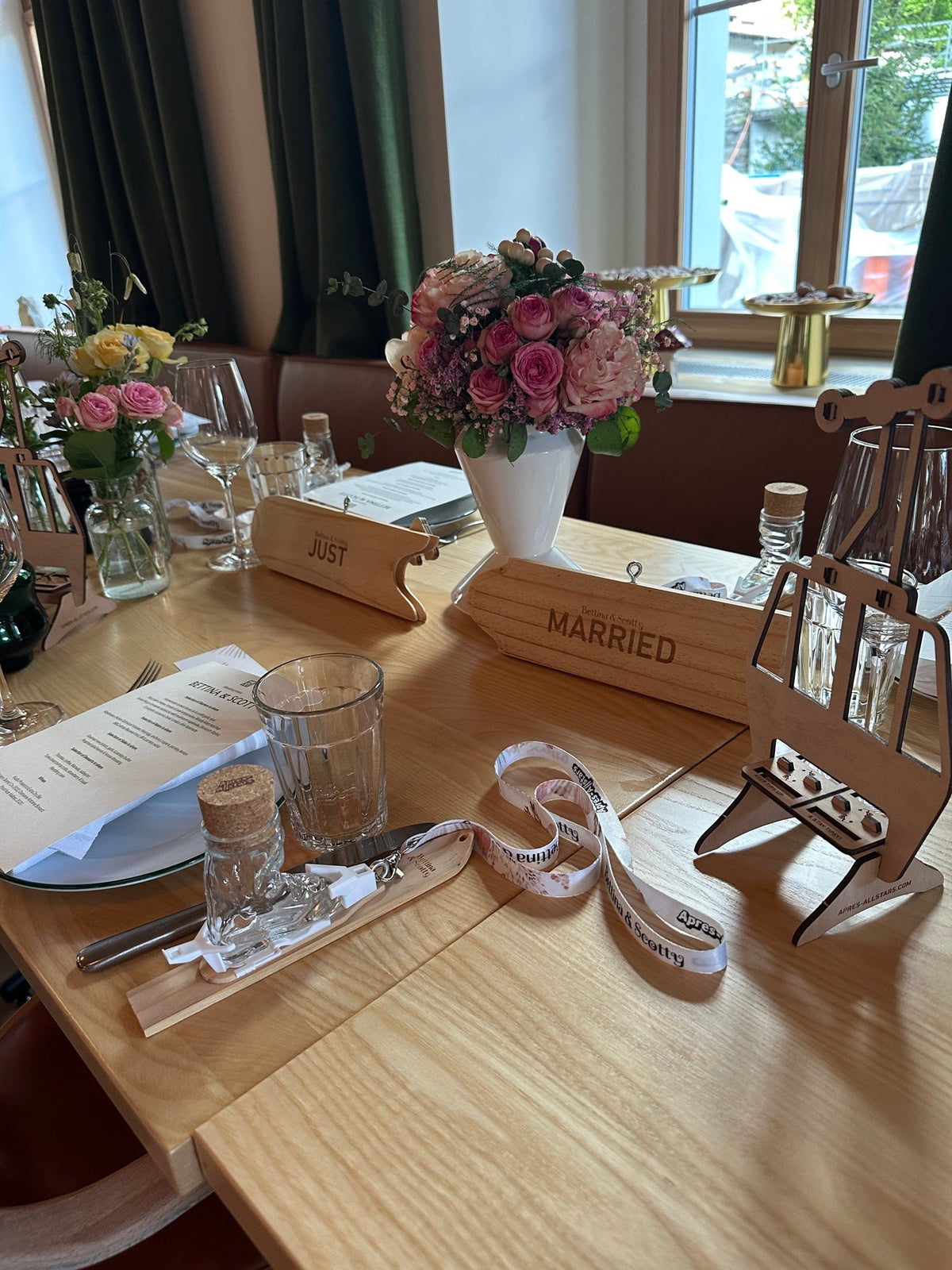 Skischuh-Schnapsgläser und ein 'Married'-Schild auf einem gedeckten Hochzeitstisch