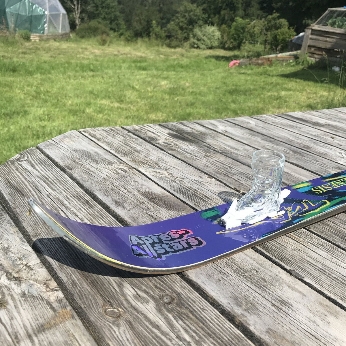 Apres-Allstars-Shotski mit Stiefelglas auf einem Holztisch im Garten