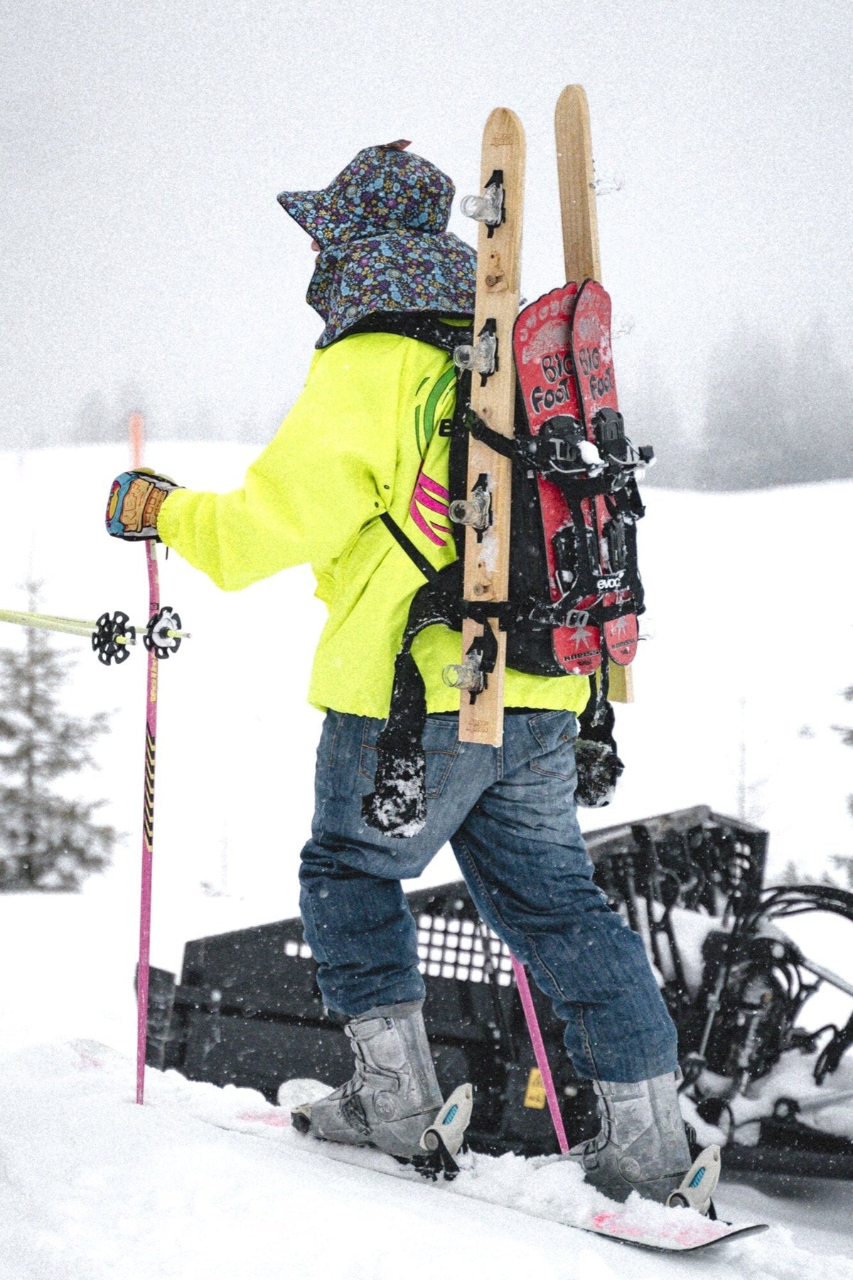 Person in Neon auf dem Snowboard mit Shotski am Rucksack — Trinkspiele fuer unterwegs