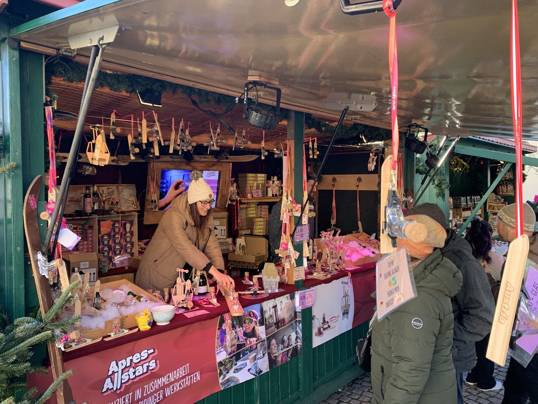 Apres-Allstars-Stand auf dem Weihnachtsmarkt mit Skischuh-Shotgläsern und Miniski