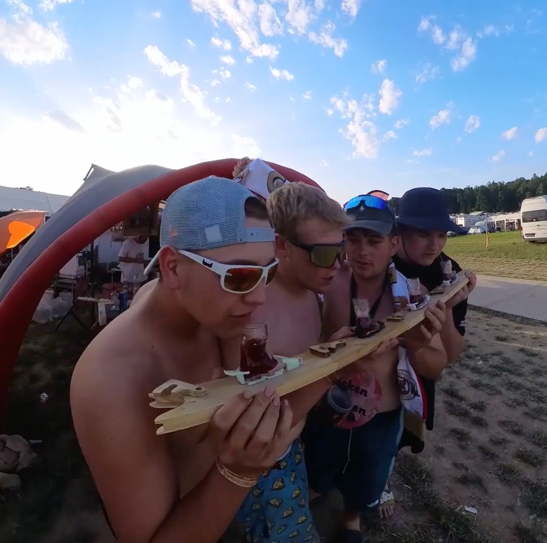 Team trinkt bei der Festival-Bierolympiade synchron aus den Gläsern eines Shotski